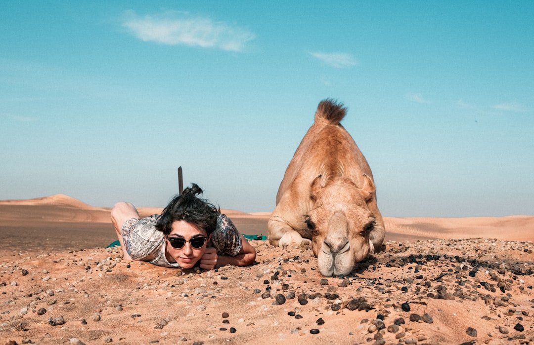 man-and-camel-lying-on-ground-hrrjixxrgfq